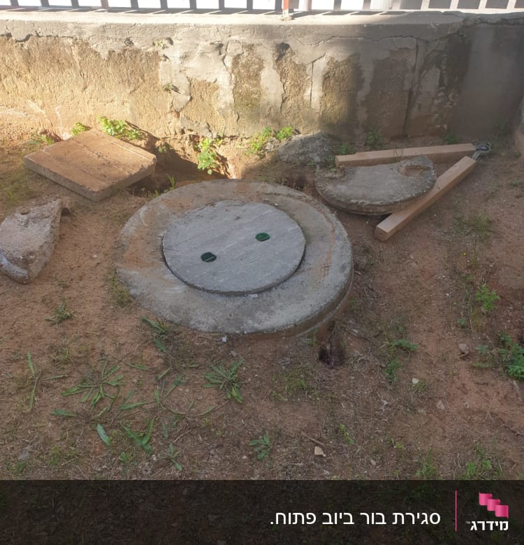 מכסה ביוב עגול עם כלי עבודה לידו